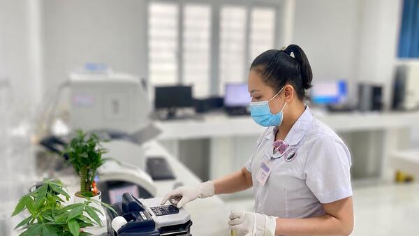 Kỹ thuật viên vận hành máy phân tích mẫu, kết nối công nghệ hiện đại với chuyên môn y tế
